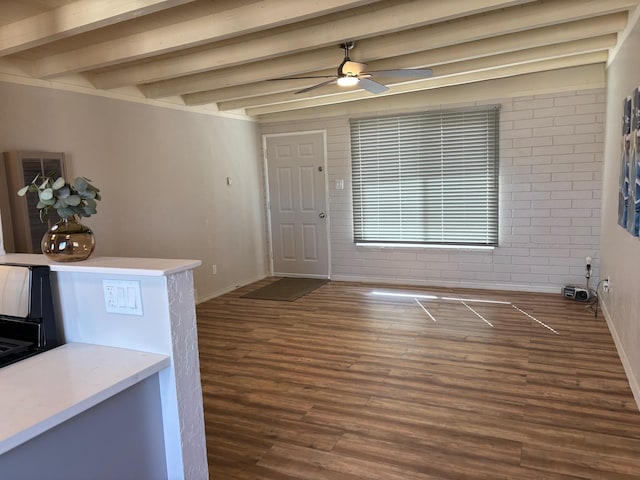 foyer entrance featuring beamed ceiling, brick wall, dark hardwood / wood-style floors, and ceiling fan