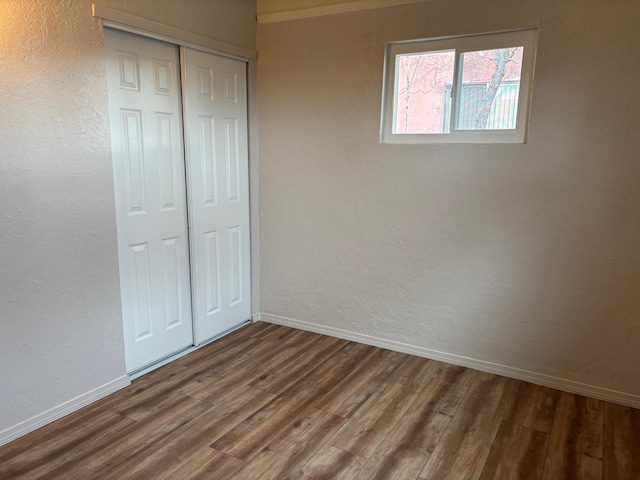 unfurnished bedroom featuring dark hardwood / wood-style flooring and a closet