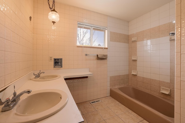 full bath with visible vents, a sink, tile walls, and tile patterned floors