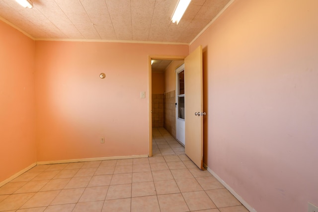 spare room with ornamental molding, baseboards, and light tile patterned floors