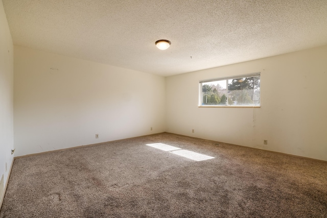 empty room with a textured ceiling and carpet flooring