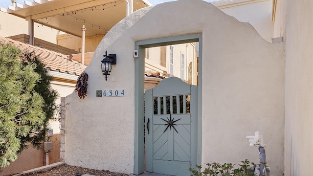 view of exterior entry with a tiled roof and stucco siding