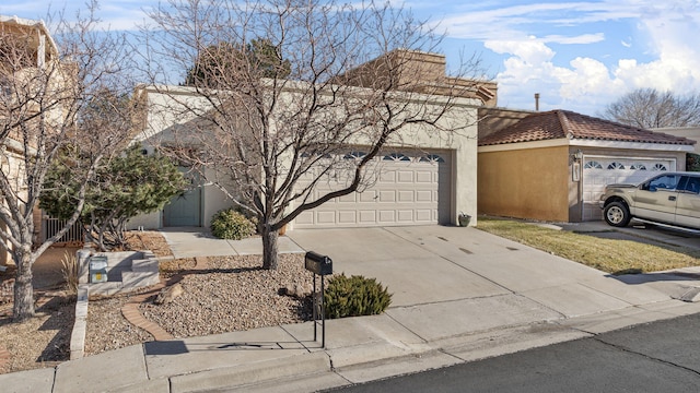 view of front of house featuring a tiled roof, an attached garage, driveway, and stucco siding