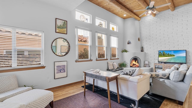 living room with a fireplace, wood finished floors, wooden ceiling, beamed ceiling, and baseboards