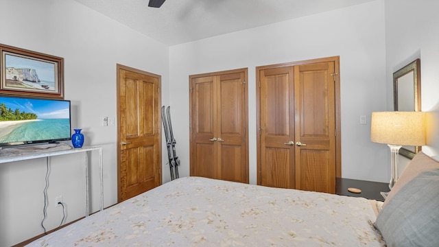 bedroom with ceiling fan and two closets