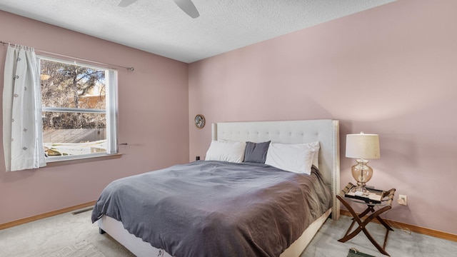 carpeted bedroom featuring ceiling fan, visible vents, baseboards, and a textured ceiling