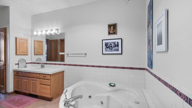 bathroom with a jetted tub, tile patterned flooring, and vanity