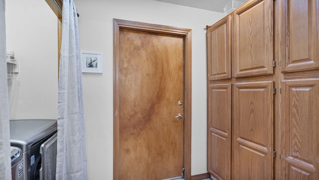 washroom with cabinet space and washing machine and clothes dryer