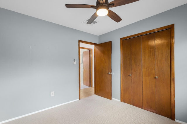 unfurnished bedroom featuring light colored carpet, a closet, and ceiling fan
