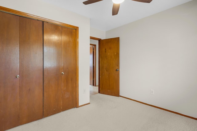 unfurnished bedroom featuring light colored carpet, a closet, and ceiling fan