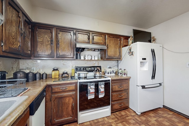 kitchen with white appliances, sink, light parquet flooring, dark brown cabinetry, and decorative backsplash