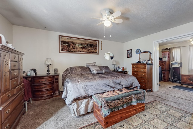 bedroom featuring a textured ceiling, light colored carpet, and ceiling fan