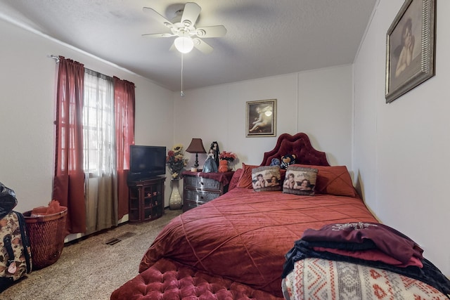carpeted bedroom with ceiling fan and a textured ceiling