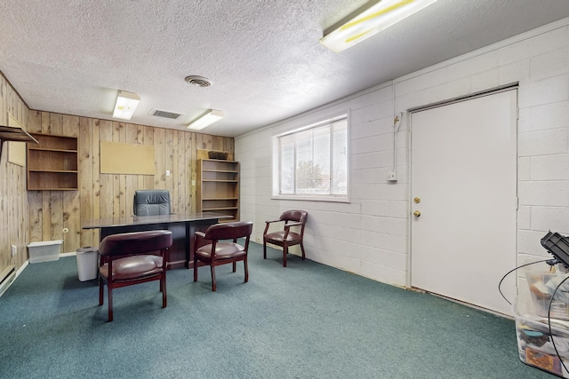 carpeted home office featuring a textured ceiling