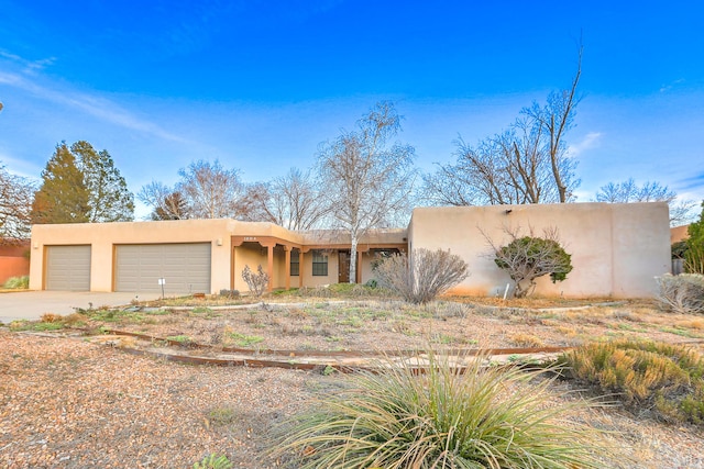 view of front of home featuring concrete driveway, an attached garage, and stucco siding