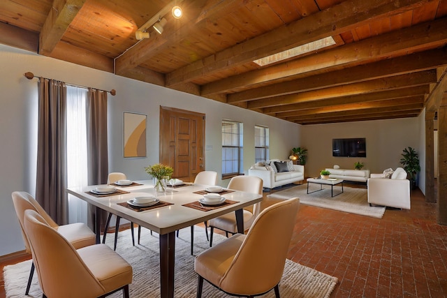 dining space featuring wooden ceiling, plenty of natural light, brick floor, and beamed ceiling