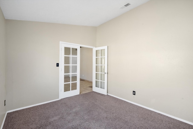 carpeted empty room with french doors and vaulted ceiling