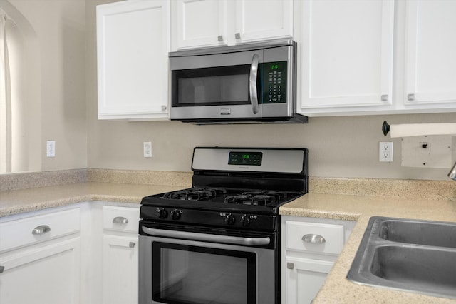 kitchen with white cabinetry, sink, and stainless steel appliances