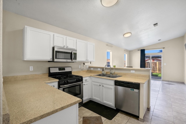 kitchen with white cabinets, appliances with stainless steel finishes, sink, and kitchen peninsula