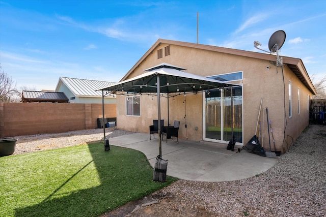 rear view of property featuring a patio and a lawn