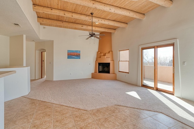 unfurnished living room featuring arched walkways, wooden ceiling, light colored carpet, visible vents, and beam ceiling