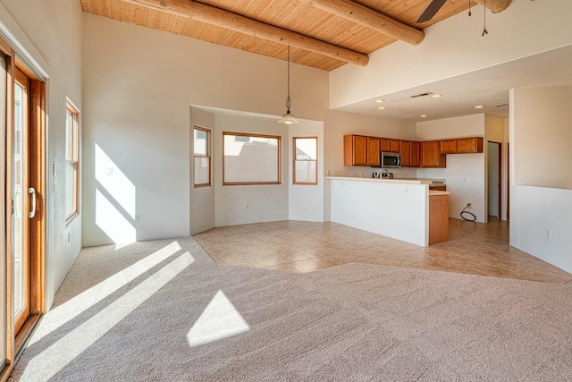 unfurnished living room featuring light tile patterned floors, beamed ceiling, wooden ceiling, and light colored carpet