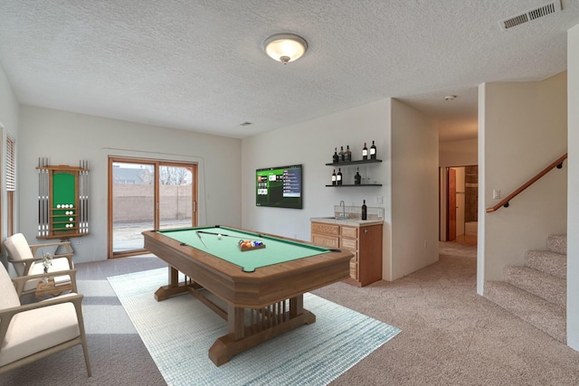 recreation room with a textured ceiling, light colored carpet, billiards, visible vents, and a bar