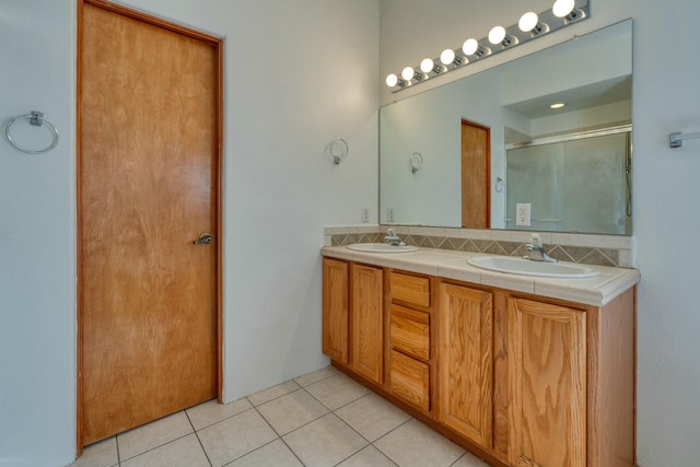 bathroom with double vanity, a sink, backsplash, and tile patterned floors