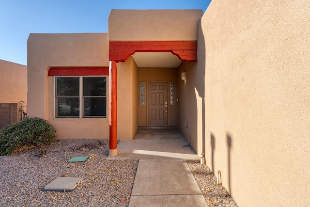 entrance to property featuring stucco siding