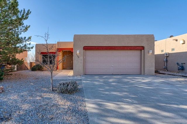 southwest-style home with driveway, an attached garage, and stucco siding