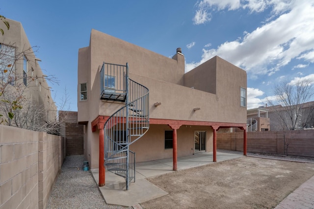 rear view of property with a patio, a fenced backyard, and stucco siding