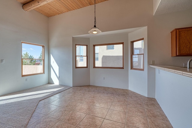 interior space with light tile patterned floors, beam ceiling, and wood ceiling