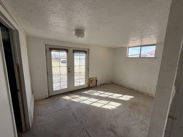 empty room with a textured ceiling and french doors