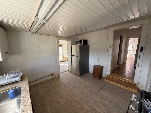 kitchen featuring appliances with stainless steel finishes, sink, wood-type flooring, and a healthy amount of sunlight