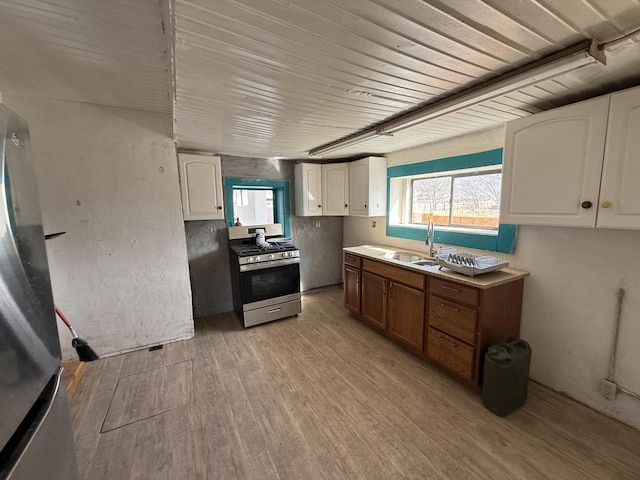 kitchen featuring light hardwood / wood-style flooring, sink, stainless steel appliances, and white cabinetry