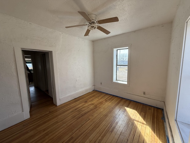 unfurnished room featuring hardwood / wood-style floors, ceiling fan, and a textured ceiling