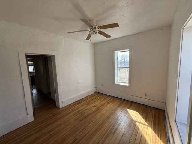 empty room featuring a textured ceiling, hardwood / wood-style flooring, and ceiling fan