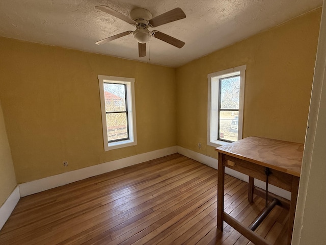 interior space featuring light wood-type flooring, ceiling fan, and a textured ceiling