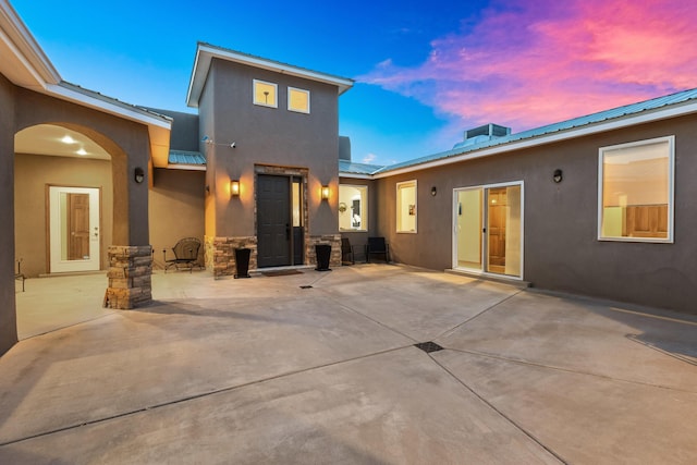 back house at dusk with a patio