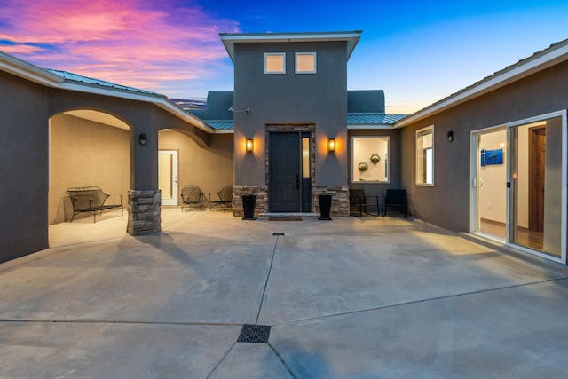 back house at dusk with a patio