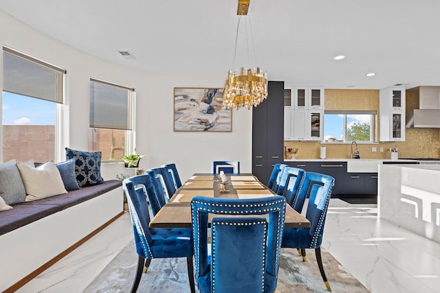 dining space with sink and a notable chandelier