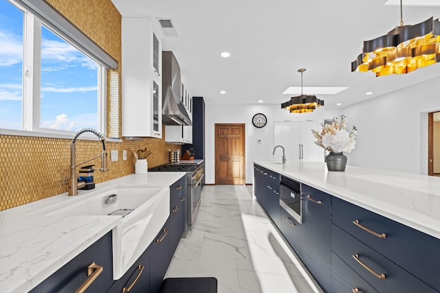 kitchen featuring sink, ventilation hood, pendant lighting, high end stove, and white cabinets