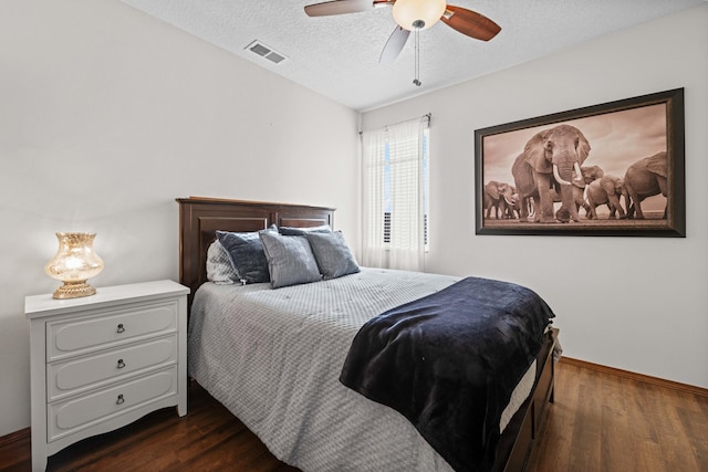 bedroom featuring ceiling fan, dark wood-type flooring, and a textured ceiling