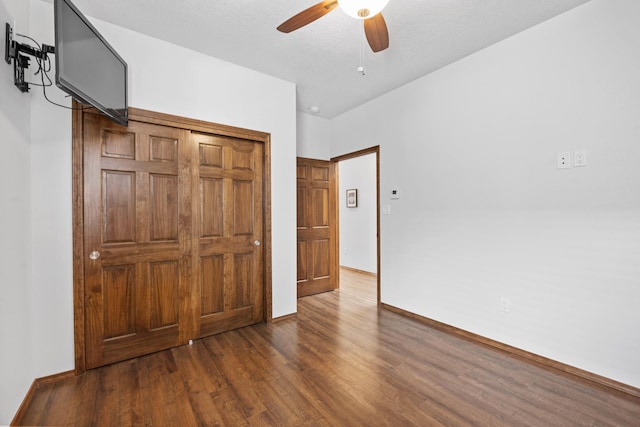 unfurnished bedroom featuring a closet, dark hardwood / wood-style floors, and ceiling fan