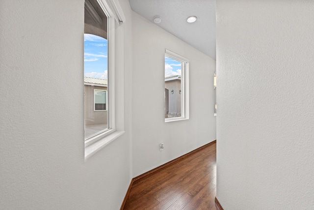 corridor with dark hardwood / wood-style flooring