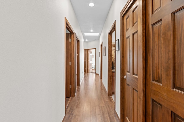 corridor with light hardwood / wood-style flooring