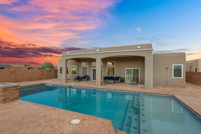 pool at dusk featuring outdoor lounge area and a patio area