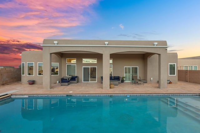 back house at dusk with a patio and an outdoor hangout area