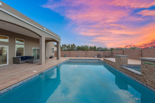 pool at dusk with an outdoor living space and a patio area