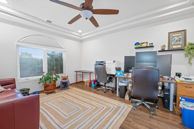 office area with ceiling fan, a tray ceiling, and hardwood / wood-style floors